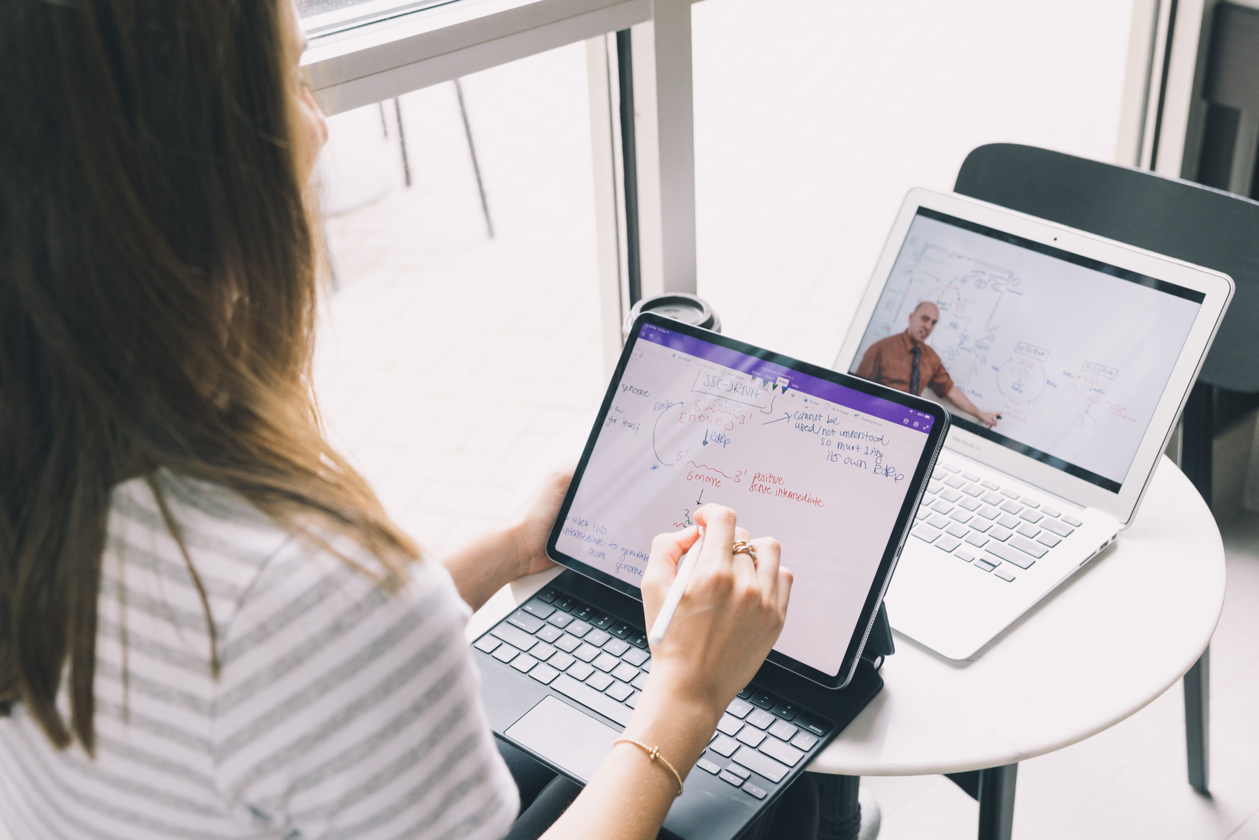 female student on laptop and tablet maximizing digital learning tools.
